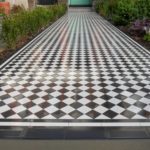 Immaculate black and white tiles installed on a long pathway in North West london