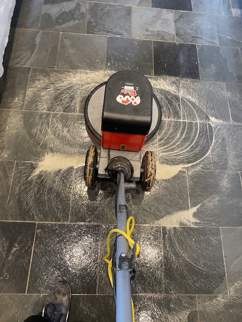 rotary floor machine scrubbing slate tiles with medium pad and chemicals
