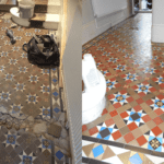 colorful geometric minton tiled hallway repaired cleaned and waxed London. Before and after pics of badly damaged dirty Victorian tiles that look great after restoration work was done