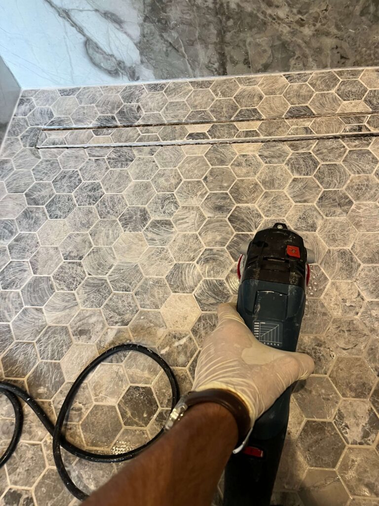 etched marble mosaic tiles on shower floor being resurfaced with polishing pads