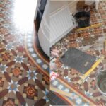 Victorian hallway tiles restoration North West London. This hallway features a curved border with coffee, brown, yellow, red and blue tiles. It was repaired in patches then deep cleaned an, sealed and waxed.